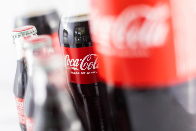 Impactos das tarifas nos custos da Coca-Cola e Ford.